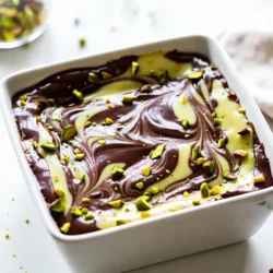 To make the perfect Pistachio Swirl Fudge, you need these key ingredients: - 1 cup sweetened condensed milk - 2 cups semi-sweet chocolate chips - 1 cup white chocolate chips - 1 cup shelled pistachios, finely chopped - 1 teaspoon vanilla extract - 1/2 teaspoon sea salt - Green food coloring (optional) These ingredients work together to create a creamy texture and a rich flavor. The sweetened condensed milk is the base that gives the fudge its melt-in-your-mouth quality. The semi-sweet and white chocolate chips add depth and sweetness, while the pistachios bring a delightful crunch. You can add a few extras if you want to enhance your fudge. Here are some fun ideas: - A pinch of cinnamon for warmth - A splash of almond extract for extra flavor - Extra nuts, like walnuts or almonds, for added texture These add-ins can give your fudge a unique twist. Feel free to experiment and find what you love. Sometimes, you might not have every ingredient on hand. Here are some easy swaps: - Use evaporated milk instead of sweetened condensed milk for a less sweet fudge. - Dark chocolate chips can replace semi-sweet chips for a richer taste. - Replace white chocolate with carob chips for a twist. These substitutions will help you make fudge that fits your taste or what you have in your kitchen. Enjoy creating your version of this sweet treat! {{ingredient_image_2}} To start, you need to prep your baking dish. Take an 8x8 inch square baking dish. Line it with parchment paper. Make sure to leave some paper hanging over the edges. This helps when you take the fudge out later. Next, we melt the chocolate. Grab a medium saucepan and place it on low heat. Add 1 cup of sweetened condensed milk and 2 cups of semi-sweet chocolate chips. Stir this mix constantly. You want it to melt into a smooth, creamy texture. Once melted, remove it from the heat. Stir in 1 teaspoon of vanilla extract and 1/2 teaspoon of sea salt. Mix well. Pour half of this chocolate mixture into your baking dish. Spread it evenly on the bottom. For the white chocolate, use the same method. Melt 1 cup of white chocolate chips in a separate bowl over low heat. Stir until it is creamy. If you want a fun green color, add a few drops of green food coloring. Mix until combined. Now, we layer the fudge. Pour the melted white chocolate over the semi-sweet layer. Spread it out smoothly. In the remaining half of the semi-sweet fudge, fold in 1 cup of finely chopped pistachios. Use a spoon to dollop spoonfuls of this pistachio fudge on top of the white layer. To create the swirl, take a knife or spatula. Gently swirl the layers together. You want a nice marbled look. Be careful not to overmix. You should still see distinct swirls of both chocolate layers. Once you finish swirling, cover the dish with plastic wrap. Place it in the fridge for at least 4 hours. This time allows the fudge to set completely. When it is firm, take it out. Lift it out of the dish using the parchment paper overhang. Place it on a cutting board. Cut it into 16 squares for serving. Enjoy your sweet and nutty treat! For a great swirl, use a gentle touch. After layering your fudge, take a knife or spatula. Start at one edge and move through the layers. Make soft, smooth motions. You want to see both chocolate types clearly. Too much mixing makes it muddy. Aim for a beautiful marbled look. Melting chocolate can be tricky. Always use low heat to avoid burning. Stir constantly as it melts. This keeps the chocolate smooth and creamy. If it gets too hot, it can seize up. If you need to melt chocolate faster, use a double boiler. This method helps heat it evenly. Make your fudge look appealing. Cut it into neat squares. Place them on a nice platter. Sprinkle extra chopped pistachios on top for color and crunch. For gifts, wrap each piece in colorful cellophane. This adds a personal touch. Friends and family will love your sweet treat! Pro Tips Use Fresh Pistachios: Ensure your pistachios are fresh for the best flavor and crunch. Stale nuts can affect the overall taste of your fudge. Temperature Control: Keep the heat low while melting chocolate to prevent it from seizing. Stir continuously for a smooth consistency. Chill for Best Texture: Allow the fudge to chill for a full 4 hours or overnight for a firmer texture that's easier to cut. Experiment with Flavors: Feel free to add other flavors like almond extract or orange zest for a unique twist on your fudge. {{image_4}} You can change the flavor of your fudge. Try dark chocolate for a rich taste. Just use dark chocolate chips instead of semi-sweet ones. If you want a fresh twist, go for matcha. Mix in matcha powder into the white chocolate layer. This gives a lovely green color and a unique flavor. You can even add spices, like cinnamon or nutmeg, for warmth and depth. Each variation brings a new adventure to this sweet treat. If you want to swap nuts, you have options! Almonds and walnuts work great in this fudge. Simply chop them finely, just like the pistachios. You can also use cashews for a creamy bite. Pecans add a nice crunch too. Each nut gives its own special flavor and texture. Mix and match to find your favorite combo! This fudge is naturally gluten-free! All the main ingredients are safe for a gluten-free diet. Just make sure to check labels on your chocolate chips. Some brands may process gluten-containing items. If you're worried, look for brands that are certified gluten-free. Enjoy this treat without any gluten concerns! To keep your pistachio swirl fudge fresh, store it in an airtight container. This helps prevent it from drying out or absorbing other smells from your fridge. You can layer the fudge squares with parchment paper. This keeps them from sticking together. Make sure to seal the container well. You can freeze fudge for later enjoyment. First, cut the fudge into squares and wrap each piece tightly in plastic wrap. After that, place the wrapped squares in a freezer-safe bag. Remove as much air as you can to prevent freezer burn. Your fudge can last in the freezer for up to three months. When stored correctly, pistachio swirl fudge can last up to two weeks in the fridge. Keep an eye on it for any signs of spoilage, like an off smell or change in texture. If you notice any, it's best to toss it out. For the best taste, enjoy your fudge within the first week. Yes, you can! Use regular milk and add sugar to thicken it. Try using evaporated milk for a richer flavor. It may change the texture, but it can still taste great. To cut the sweetness, reduce the sugar in the recipe. You can use dark chocolate chips instead of semi-sweet ones. Adding a pinch of sea salt can also balance the sweetness nicely. Check local bakeries or specialty candy shops for pre-made fudge. Some grocery stores carry it in their dessert section. You can also find it online at various sweet treat retailers. Absolutely! You can swap pistachios for almonds, walnuts, or hazelnuts. Each nut brings its own flavor and crunch, making the fudge unique. Just chop the nuts finely before adding them to the mix. This guide covers all you need to make delicious Pistachio Swirl Fudge. We explored the main ingredients, optional add-ins, and substitutions. The step-by-step instructions help you create the perfect swirl. Tips and tricks ensure great results, while variations add fun flavors. Lastly, we discussed how to store fudge and answered common questions. Enjoy making this treat and share it with others! The joys of baking are waiting for you.